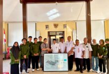 Tim mahasiswa Geografi UMS dan perangkat Desa Waru berfoto bersama memegang Peta Desa Waru sebagai simbol kerja sama pembangunan berbasis data.