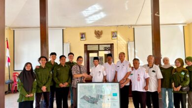 Tim mahasiswa Geografi UMS dan perangkat Desa Waru berfoto bersama memegang Peta Desa Waru sebagai simbol kerja sama pembangunan berbasis data.