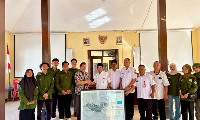 Tim mahasiswa Geografi UMS dan perangkat Desa Waru berfoto bersama memegang Peta Desa Waru sebagai simbol kerja sama pembangunan berbasis data.
