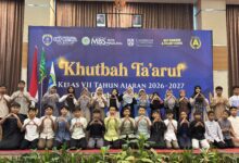 Siswa baru kelas VII SMP Mutual Kota Magelang berfoto bersama dalam acara Khutbah Ta’aruf tahun ajaran 2026/2027 dengan latar belakang spanduk kegiatan.