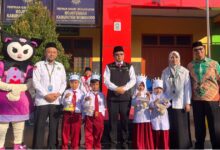 Siswa baru membawa kurungan berisi bibit ayam saat pembukaan kegiatan MATAMUDA MI Hamka Wonosobo bersama Kasi Pendidikan Madrasah Kemenag Wonosobo.