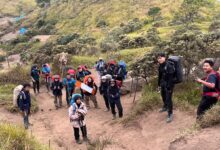 Aksi kader Hizbul Wathan UMS mendaki jalur tanah berpasir di Gunung Merbabu membawa perlengkapan edukasi dan tas gunung.