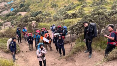 Aksi kader Hizbul Wathan UMS mendaki jalur tanah berpasir di Gunung Merbabu membawa perlengkapan edukasi dan tas gunung.