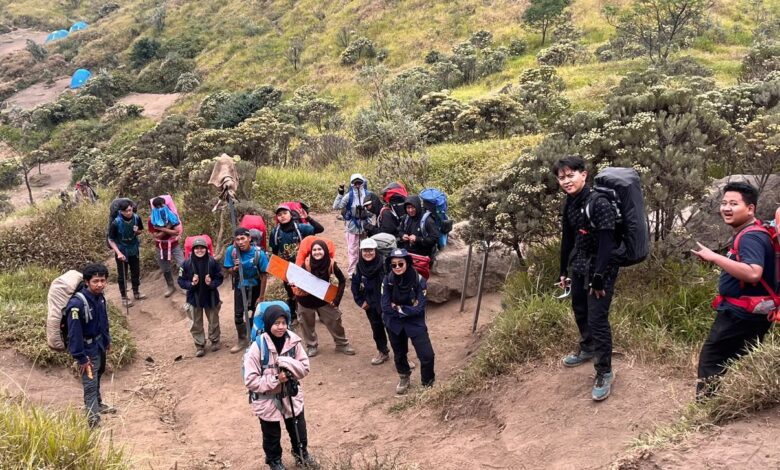Aksi kader Hizbul Wathan UMS mendaki jalur tanah berpasir di Gunung Merbabu membawa perlengkapan edukasi dan tas gunung.