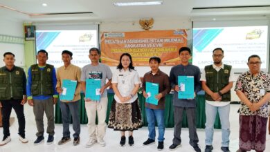 Sembilan orang pria berdiri berpose di depan spanduk pelatihan di sebuah ruangan.