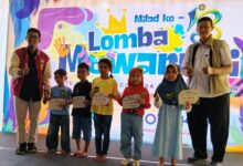 Lima anak penerima beasiswa pendidikan anak dari Pemuda Muhammadiyah Kroya berdiri bersama dua panitia sambil memegang sertifikat di acara Milad ke-3 RSU PKU Muhammadiyah Aghisna.