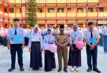 Sekelompok siswa dan seorang Kepala Sekolah berdiri di depan spanduk acara sekolah di SMK Muhammadiyah 3 Purwokerto, dengan tulisan MAJU BERSAMA SUKSES MULIA.