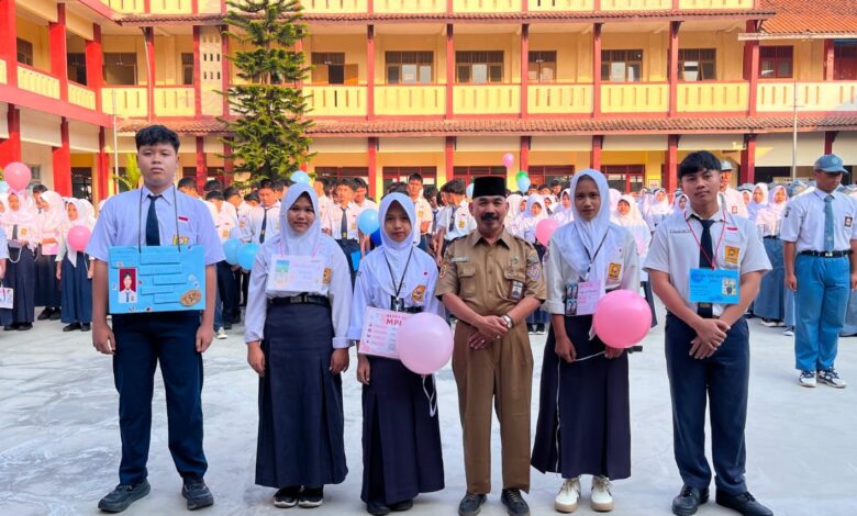 Sekelompok siswa dan seorang Kepala Sekolah berdiri di depan spanduk acara sekolah di SMK Muhammadiyah 3 Purwokerto, dengan tulisan MAJU BERSAMA SUKSES MULIA.