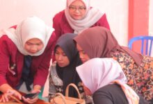 Mahasiswa UNIMUS mendampingi pelaku UMKM Desa Taruman Grobogan belajar cara jualan di Shopee Live menggunakan smartphone.