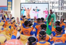 Siswa baru SD Muhammadiyah PK Solo berpartisipasi aktif dalam kegiatan MPLS Ramah yang dipandu dari layar. Mereka mengenakan atribut lengkap berwarna oranye dan biru.