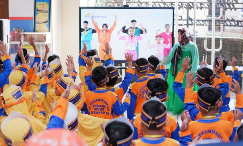 Siswa baru SD Muhammadiyah PK Solo berpartisipasi aktif dalam kegiatan MPLS Ramah yang dipandu dari layar. Mereka mengenakan atribut lengkap berwarna oranye dan biru.