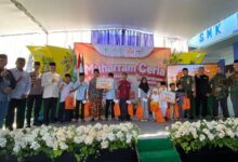 Foto bersama tokoh masyarakat, pejabat Forkopimcam, dan anak-anak penerima santunan di panggung utama acara Muharram Ceria Lazismu Wonosobo di Wadaslintang. Anak-anak memegang bingkisan berwarna oranye.