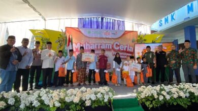 Foto bersama tokoh masyarakat, pejabat Forkopimcam, dan anak-anak penerima santunan di panggung utama acara Muharram Ceria Lazismu Wonosobo di Wadaslintang. Anak-anak memegang bingkisan berwarna oranye.