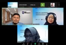 Tangkapan layar pertemuan online Zoom Workplace untuk Dialog Akademik Program Studi Arsitektur UMS. Gambar menunjukkan beberapa ubin video peserta dan panelis, termasuk tiga pembicara utama di baris tengah dan bawah. Salah satu panelis memiliki latar belakang bermerek "BIM UNIVERSITY". Panelis lain menggunakan latar belakang virtual yang menampilkan informasi acara: "DIALOG AKADEMIK Bersama Orang Tua/Wali Mahasiswa 'Sinergi Kampus dan Keluarga Mendukung Mental dan Produktivitas Mahasiswa'", logo UMS, dan tanggal Rabu, 15 Juli 2026. Antarmuka Zoom menampilkan kontrol seperti "Participants," "Chat," "Share Screen," "Leave," dan bilah pencarian Windows.
