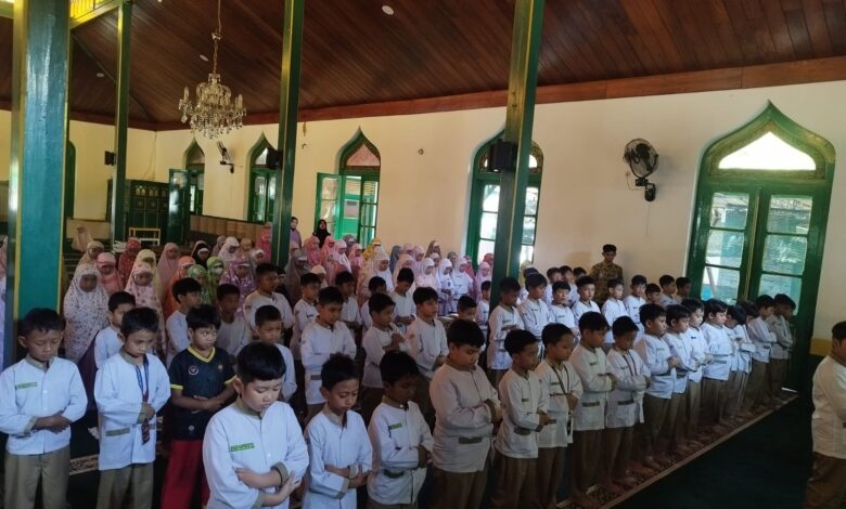 Ratusan siswa SD Muhammadiyah 1 Solo berseragam putih dan mukena berbaris rapih khusyuk menunaikan salat berjamaah di dalam masjid dengan pilar kayu hijau.