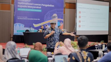 Dr. Budi Santoso memaparkan materi penulisan berita dalam Workshop Pengabdian Masyarakat UMS di hadapan peserta. Di latar belakang terlihat banner workshop dan layar proyektor dengan poin Anatomi Berita.