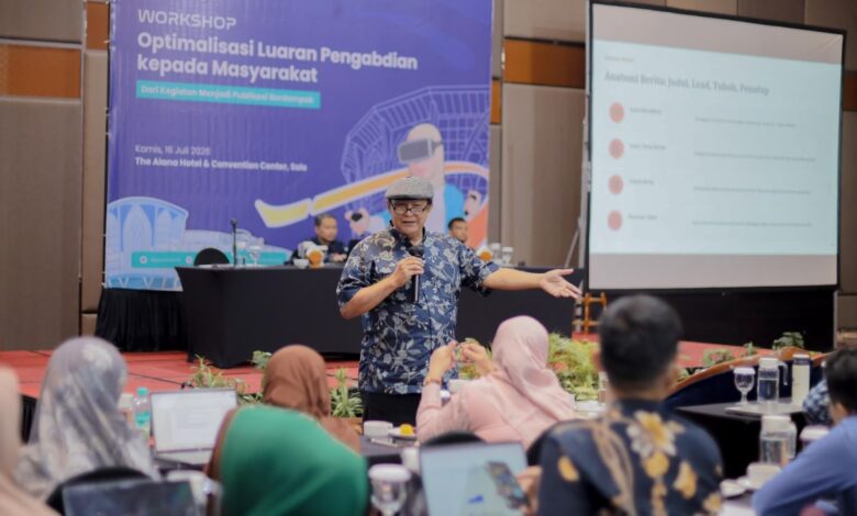 Dr. Budi Santoso memaparkan materi penulisan berita dalam Workshop Pengabdian Masyarakat UMS di hadapan peserta. Di latar belakang terlihat banner workshop dan layar proyektor dengan poin Anatomi Berita.
