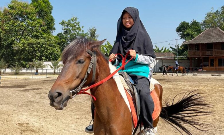 Siswi SMP Ahmad Dahlan Sukoharjo sedang mencoba olahraga berkuda dalam rangkaian kegiatan MPLS Ramah Anak di Al Birru Stable.