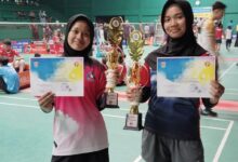 Dua siswi SMP Muhammadiyah 1 Alternatif (Mutual) Kota Magelang menunjukkan piala dan sertifikat juara bulutangkis.