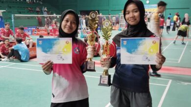 Dua siswi SMP Muhammadiyah 1 Alternatif (Mutual) Kota Magelang menunjukkan piala dan sertifikat juara bulutangkis.