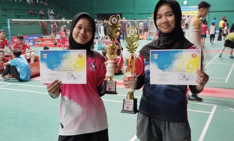 Dua siswi SMP Muhammadiyah 1 Alternatif (Mutual) Kota Magelang menunjukkan piala dan sertifikat juara bulutangkis.