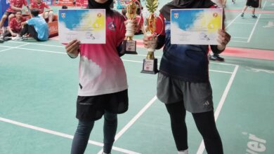 Dua siswi SMP Muhammadiyah 1 Alternatif (Mutual) Kota Magelang menunjukkan piala dan sertifikat juara bulutangkis.