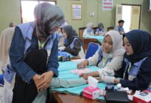 Mahasiswa Farmasi UMP melakukan pemeriksaan kadar hemoglobin warga untuk deteksi dini dan mengenali ciri ciri anemia.