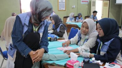 Mahasiswa Farmasi UMP melakukan pemeriksaan kadar hemoglobin warga untuk deteksi dini dan mengenali ciri ciri anemia.