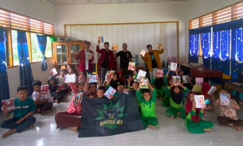 Anggota BikersMu Chapter Banggai berfoto bersama anak-anak sekolah pedalaman Tobiombong yang memegang buku bantuan.
