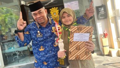 Tabina Khansa Nirwasita berfoto bersama gurunya sambil memegang piala juara 1 lomba menulis cerita.