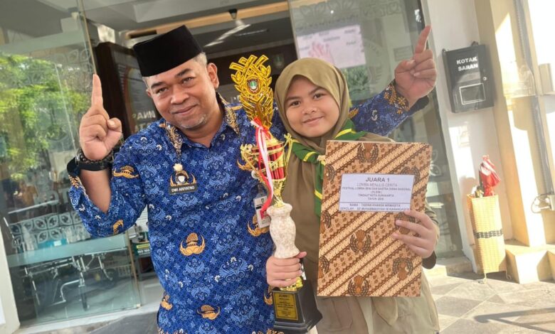 Tabina Khansa Nirwasita siswi SD Muhammadiyah 16 Surakarta memegang piala Juara 1 lomba menulis cerita FLS3N Surakarta 2026