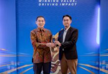 Wakil Rektor UMS Prof Supriyono dan Wakil Dekan FKIP UMS Dr Miftakhul Huda memegang trofi penghargaan SBBI Awards 2026 dengan latar belakang panggung biru bertuliskan Winning Value Driving Impact.
