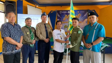 Salamun dari PDM menyerahkan bendera Hizbul Wathan kepada perwakilan siswa SMP Muhammadiyah 1 Alternatif Kota Magelang dalam pelepasan kontingen ISC ke Thailand.