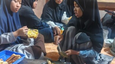 Sekelompok santri putri berhijab di Pondok Pesantren Muhammadiyah Manafi'ul Ulum Sambi berkolaborasi membuat pizza mini di wajan sebagai bagian dari praktik santri belajar bisnis kuliner.