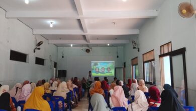 Seorang pembicara sedang memaparkan materi tentang pendidikan anak di depan audiens dalam sebuah seminar parenting di aula masjid.