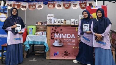 Tiga wanita berhijab memegang brosur pendaftaran siswa baru di depan stan pameran produk kedai kopi lokal MIMDA Coffee milik MI Muhammadiyah Danurejo saat acara Car Free Day di Alun-alun Temanggung.