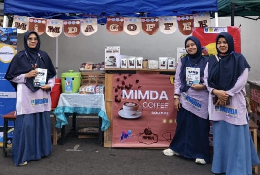 Tiga wanita berhijab memegang brosur pendaftaran siswa baru di depan stan pameran produk kedai kopi lokal MIMDA Coffee milik MI Muhammadiyah Danurejo saat acara Car Free Day di Alun-alun Temanggung.