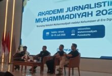 Empat narasumber duduk di panggung pada pembukaan Akademi Jurnalistik Muhammadiyah 2026 di Universitas Muhammadiyah Purwokerto. Layar latar menampilkan tema branding sekolah Muhammadiyah di era digital.