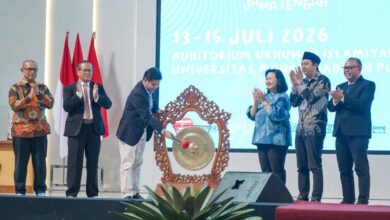 Enam pejabat universitas di atas panggung dalam acara pembukaan, dengan seorang pria memukul gong besar untuk meresmikan acara Lomba Dangdut Peksimida Jateng 2026 di UMP. Di latar belakang terdapat layar LED besar bertuliskan teks acara.