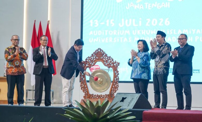 Enam pejabat universitas di atas panggung dalam acara pembukaan, dengan seorang pria memukul gong besar untuk meresmikan acara Lomba Dangdut Peksimida Jateng 2026 di UMP. Di latar belakang terdapat layar LED besar bertuliskan teks acara.