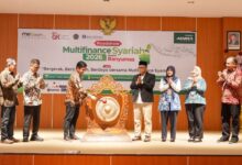Sekelompok pejabat dan tokoh masyarakat di panggung Aula UMP menyaksikan salah satu pejabat memukul gong sebagai simbol pembukaan Roadshow Multifinance Syariah 2026 dan Musda MES Banyumas, Kamis (16/7), didampingi perwakilan OJK, Bank Indonesia, dan UMP.