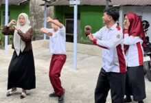 Empat orang, termasuk mahasiswa UNIMMA dan siswa berkebutuhan khusus berhijab, sedang menari bersama di area parkir sekolah.