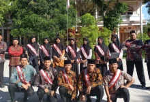 Jajaran pimpinan, ustadz, ustadzah, dan santri petugas upacara mengenakan selempang berfoto bersama di halaman pesantren pada momen pencanangan Pekan Bahasa PonpesMU Manafi'ul 'Ulum.