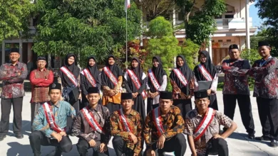 Jajaran pimpinan, ustadz, ustadzah, dan santri petugas upacara mengenakan selempang berfoto bersama di halaman pesantren pada momen pencanangan Pekan Bahasa PonpesMU Manafi'ul 'Ulum.