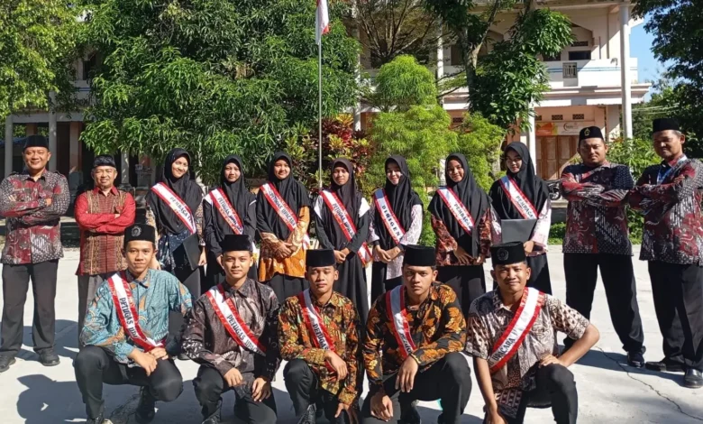 Jajaran pimpinan, ustadz, ustadzah, dan santri petugas upacara mengenakan selempang berfoto bersama di halaman pesantren pada momen pencanangan Pekan Bahasa PonpesMU Manafi'ul 'Ulum.