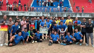 Foto bersama juara pertama Kejuaraan Sepak Bola PDM Wonosobo Piala PSHW di Stadion Gelora Pancasila, berpose dengan piala dan papan hadiah uang tunai Rp1.500.000, dikelilingi ofisial dan penonton di tribun merah-biru.