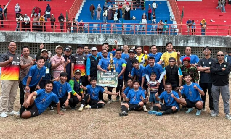 Foto bersama juara pertama Kejuaraan Sepak Bola PDM Wonosobo Piala PSHW di Stadion Gelora Pancasila, berpose dengan piala dan papan hadiah uang tunai Rp1.500.000, dikelilingi ofisial dan penonton di tribun merah-biru.