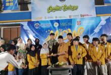 Kepala SMP Mutual Kota Magelang secara simbolis menyerahkan tumpeng Milad ke-65 IPM kepada Ketua IPM di panggung acara.