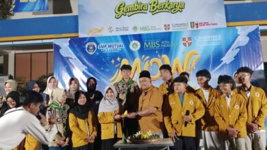 Kepala SMP Mutual Kota Magelang secara simbolis menyerahkan tumpeng Milad ke-65 IPM kepada Ketua IPM di panggung acara.