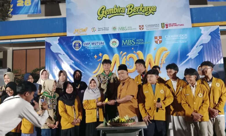 Kepala SMP Mutual Kota Magelang secara simbolis menyerahkan tumpeng Milad ke-65 IPM kepada Ketua IPM di panggung acara.